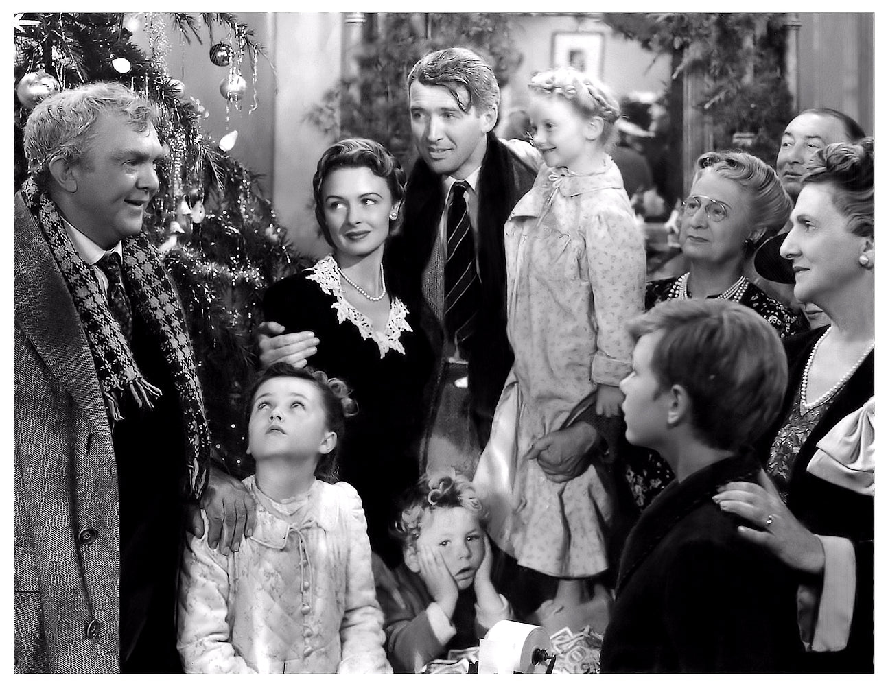 Black and white scene of a family gathered around a Christmas tree